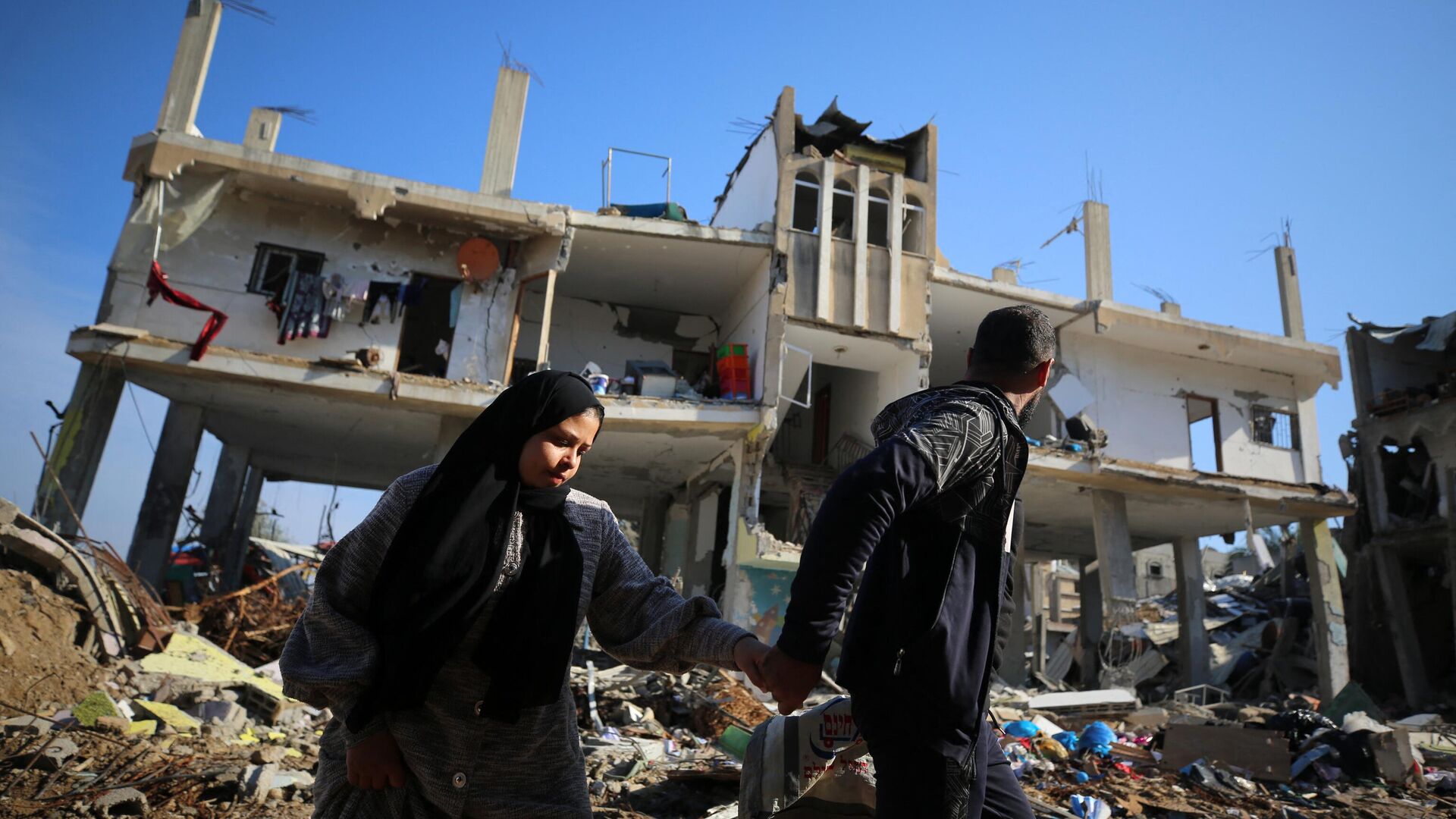 Палестинцы проходят мимо разрушенного здания в лагере беженцев Аль-Магази в центре сектора Газа - اسپوتنیک افغانستان  , 1920, 01.02.2024