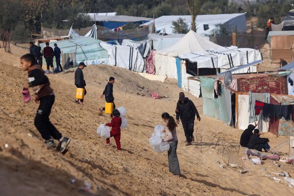 حمل وسایل برای جمع آوری آب در اردوگاه آوارگان فلسطینی در مرز با مصر. - اسپوتنیک افغانستان  