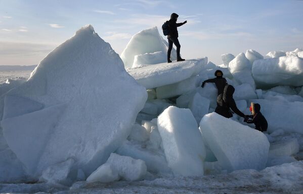 مردم در نزدیکی پشته های یخی که به دلیل بادهای شدید در ساحل خلیج آمور در قلمرو پریمورسکی شکل گرفتند. - اسپوتنیک افغانستان  