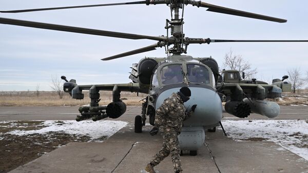 Военнослужащий группировки войск Центр ВС РФ подготавливает разведывательно-ударный вертолет Ка-52 к вылету в зоне СВО - اسپوتنیک افغانستان  