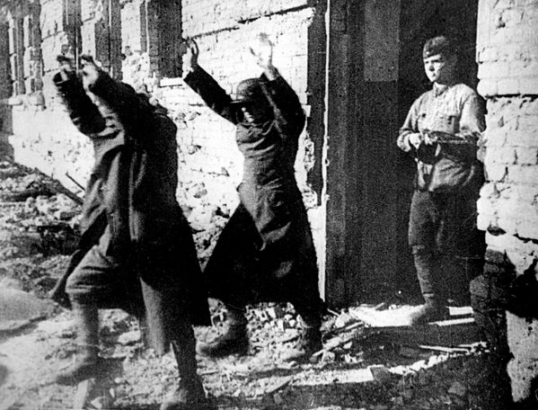 در حالی که سربازان آلمانی در جون از استالینگراد اخراج می شوند، دو سرباز محور، در حالی که دست هایشان را بالای سرشان گرفته اند، توسط یکی از اسیرکنندگان روسی از یک ساختمان کتک خورده بیرون رانده می شوند. 25، 1943 در طول جنگ جهانی دوم. - اسپوتنیک افغانستان  