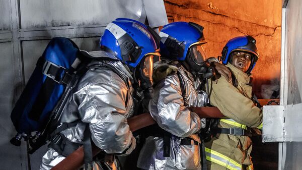 آتش نشانان در پی وقوع یک رشته انفجار در منطقه امباکاسی در نایروبی، کنیا، با آتش مبارزه می کنند. - اسپوتنیک افغانستان  