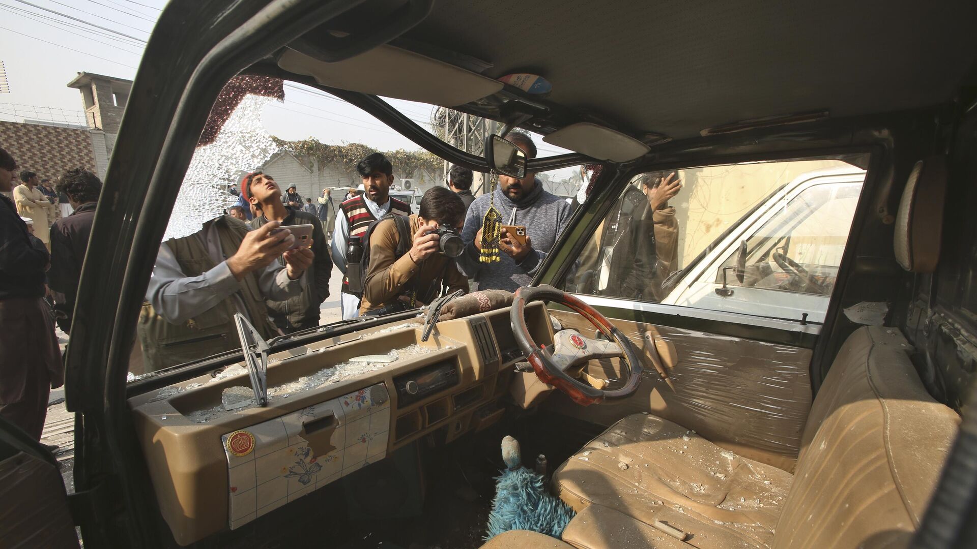 Представители СМИ снимают поврежденный автомобиль на месте взрыва бомбы в Пешаваре, Пакистан - اسپوتنیک افغانستان  , 1920, 07.02.2024