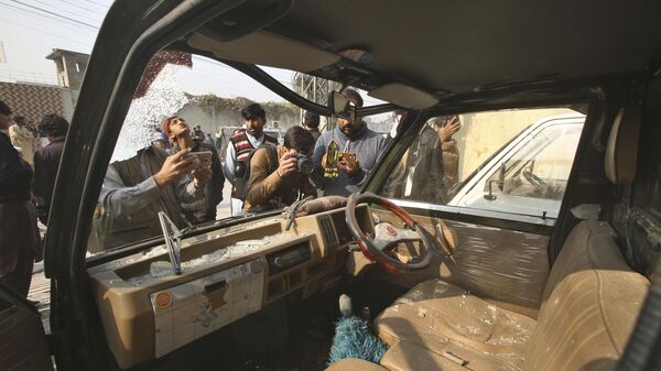 Представители СМИ снимают поврежденный автомобиль на месте взрыва бомбы в Пешаваре, Пакистан - اسپوتنیک افغانستان  