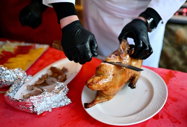 آشپزی در جشنواره سال نو چینی در مسکو   اردک کباب را با چاقو می برد . - اسپوتنیک افغانستان  