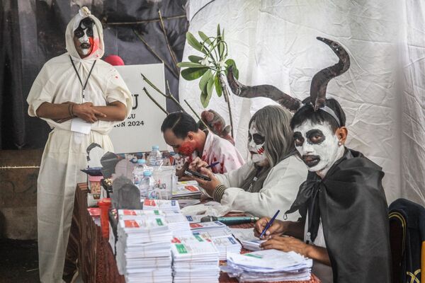 کارمندان با لباس‌هایی با مضمون ترسناک در یک مرکز رأی‌گیری در جریان انتخابات ریاست‌جمهوری و پارلمانی اندونزیا. - اسپوتنیک افغانستان  