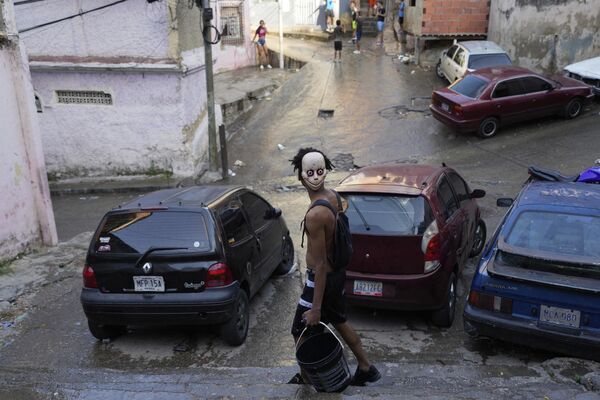 مرد و سطل در جریان برگزاری جشن های کارناوال در محله سان آگوستین در کاراکاس، ونزوئلا. - اسپوتنیک افغانستان  