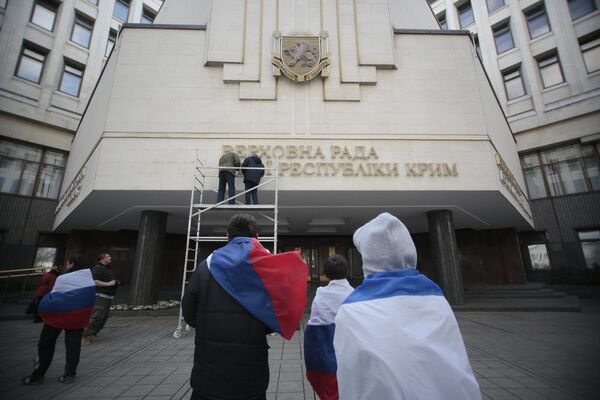 کارگران تابلوی پارلمان جمهوری خودمختار کریمه  به زبان اوکراینی را پایین می کشند. - اسپوتنیک افغانستان  