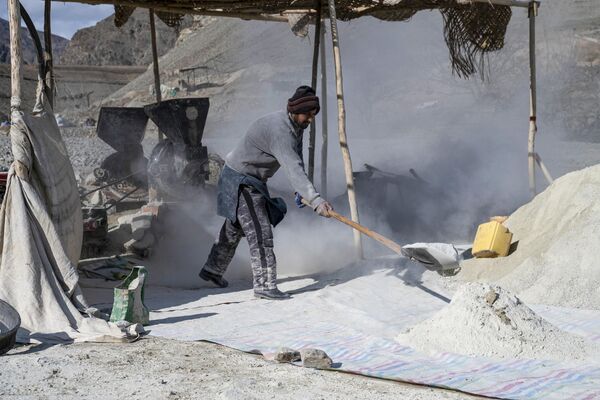 کار یک مرد افغانستانی در بیرون از یک معدن طلا در کوه های ولسوالی یفتل پایین ولایت بدخشان با یک ماشین آسیاب. - اسپوتنیک افغانستان  