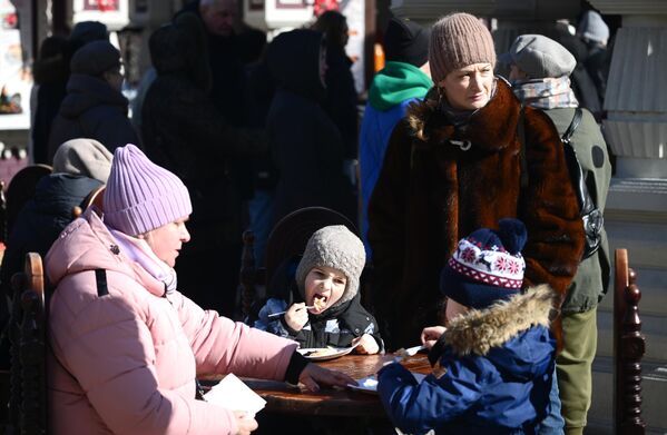 مردم در جشنواره ماسلنیتسا در میدان انقلاب در مسکو پنکیک می خورند. - اسپوتنیک افغانستان  