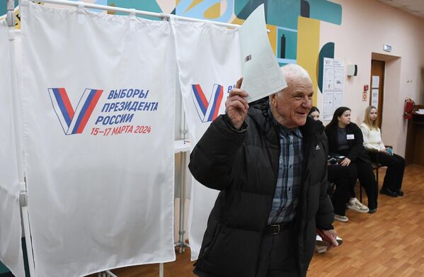 مردی در انتخابات ریاست جمهوری روسیه در شعبه رای گیری شماره 4127 در ولادی وستوک رای می دهد. - اسپوتنیک افغانستان  