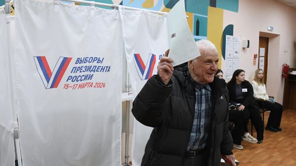 Мужчина голосует на выборах президента России на избирательном участке №4127 во Владивостоке - اسپوتنیک افغانستان  