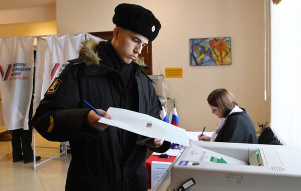 یک سرباز ناوگان اقیانوس آرام در انتخابات ریاست جمهوری روسیه در شعبه رای گیری شماره 502 در ولادی وستوک رای می دهد. - اسپوتنیک افغانستان  