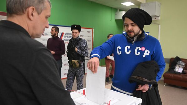 Мужчина голосует на выборах президента России на избирательном участке школы №2123 в Москве - اسپوتنیک افغانستان  