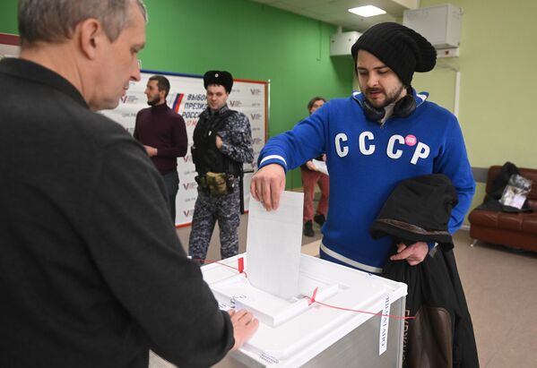 مردی در انتخابات ریاست جمهوری روسیه در شعبه رای گیری مکتب شماره 2123 مسکو رای می دهد. - اسپوتنیک افغانستان  