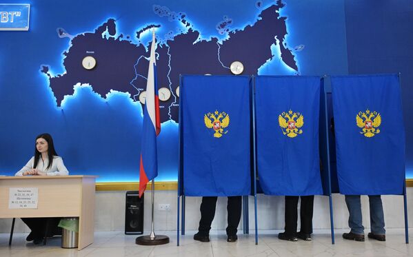 مردم در انتخابات ریاست جمهوری روسیه در یکی از مرکزهای رای گیری در نووسیبیرسک رای می دهند. - اسپوتنیک افغانستان  