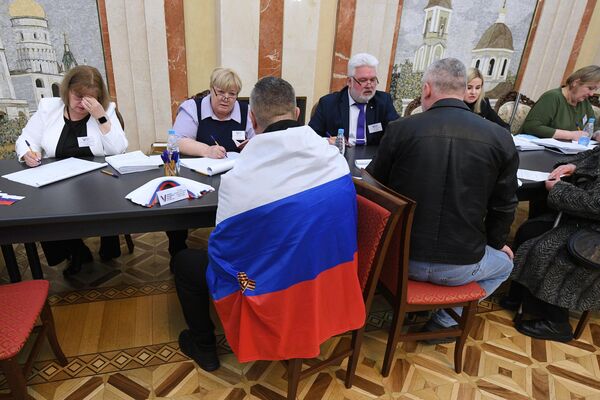 مردم در جریان انتخابات ریاست جمهوری روسیه در یک شعبه رای گیری در سفارت روسیه در مینسک رای می دهند. - اسپوتنیک افغانستان  