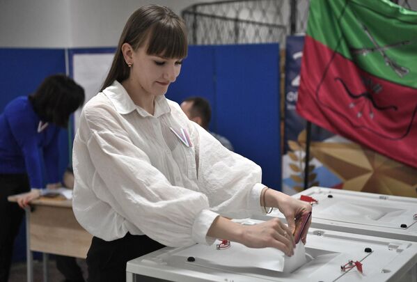 یک زن در انتخابات ریاست جمهوری روسیه در یک مرکز رای گیری در کنستانتینوفکا رای می دهد. - اسپوتنیک افغانستان  