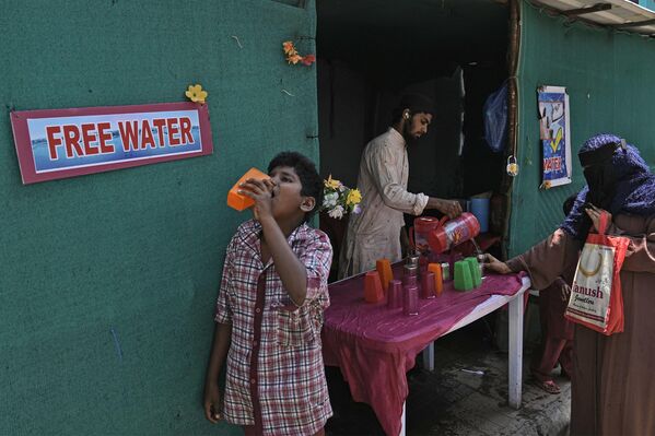 تاریخ تصحیح - داوطلبی آب آشامیدنی را در کنار ایستگاه اتوبوس در یک روز گرم تابستانی در حیدرآباد، هند، پنجشنبه، 21 مارس 2024 توزیع می کند. مردم در بسیاری از مناطق هند در ماه های تابستان آب آشامیدنی رایگان را در اختیار مسافران قرار می دهند. جمعه مصادف با روز جهانی آب است. (عکس آسوشیتدپرس/ماهش کومار آ.) - اسپوتنیک افغانستان  