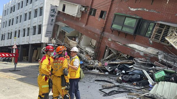 Члены поисково-спасательной команды возле наклонившегося здания после землетрясения в Хуаляне, восточный Тайвань, Китай - اسپوتنیک افغانستان  