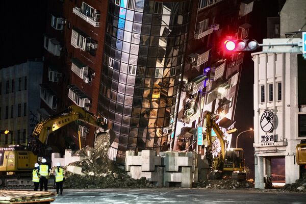 پرسنل کمک های ع اجل در 3 اپریل 2024 پس از زلزله بزرگی که شرق تایوان را لرزاند، در مقابل یک ساختمان نیمه فرو ریخته ایستاده است. حداقل 9 نفر در 3 اپریل بر اثر زمین لرزه قدرتمند در تایوان که به ده ها ساختمان آسیب رساند و هشدارهای سونامی را در پی داشت، کشته و بیش از 1000 مجروح شدند قبل از برداشتن آن به ژاپن و فیلیپین نیز کشیده شد. - اسپوتنیک افغانستان  