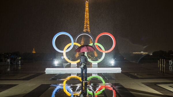 Турист фотографирует Олимпийские Кольца на площади Трокадеро в Париже - اسپوتنیک افغانستان  