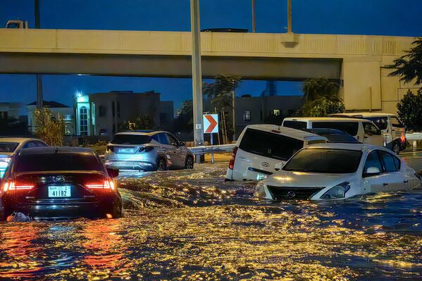 به دنبال باران‌های شدید در دبی در 17 اپریل 2024،موترها در جاده پر آب می‌روند. دبی، مرکز مالی خاورمیانه، در اثر باران سیل آسا فلج شده است که باعث سیل در امارات و بحرین شد و 18 کشته در عمان در 14اپریل برجای گذاشت. 15. (عکس از Giuseppe CACACE / AFP) - اسپوتنیک افغانستان  