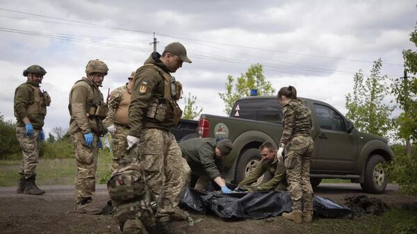 Военные медики укладывают тела убитых украинских солдат в пластиковые пакеты на дороге под Артемовском - اسپوتنیک افغانستان  