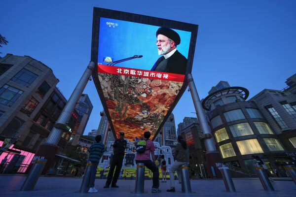 ساکنان پکن در حال تماشای خبر مربوط به درگذشت ابراهیم رئیسی، رئیس‌جمهور ایران. - اسپوتنیک افغانستان  