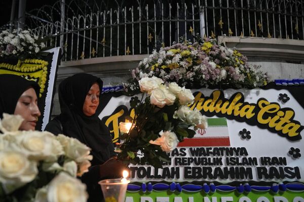زنان در مراسم شمع‌افروزی به یاد ابراهیم رئیسی رئیس‌جمهور ایران در برابر سفارت ایران در جاکارتا، اندونزیا. - اسپوتنیک افغانستان  