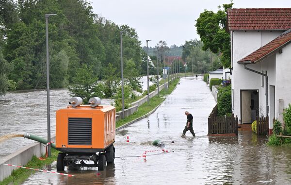 مردی در 2 جون 2024 از خیابانی سیل زده در بار-ابنهاوزن عبور می کند. باران های شدید از 31 می 2024 به بعد منجر به جاری شدن سیل در ایالت های بادن-وورتمبرگ و باواریا در جنوب آلمان شده است - اسپوتنیک افغانستان  
