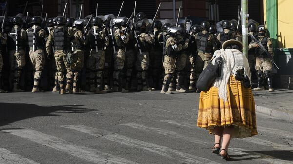 Женщина проходит мимо военной полиции на площади Мурильо в Ла-Пасе, Боливия - اسپوتنیک افغانستان  