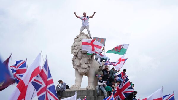 A demonstrator stands on the head of the South Bank lion that sits on the side of the Westminster Bridge, during a Tommy Robinson-led Unite the Kingdom march and rally in London - اسپوتنیک افغانستان  