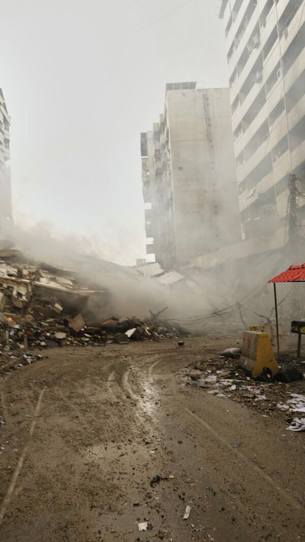 A man photographs the rubble of buildings destroyed in an Israeli airstrike in Dahiyeh, Beirut's southern suburbs, Lebanon, Sunday, March 15, 2026. (AP Photo/Hassan Ammar) - اسپوتنیک افغانستان  