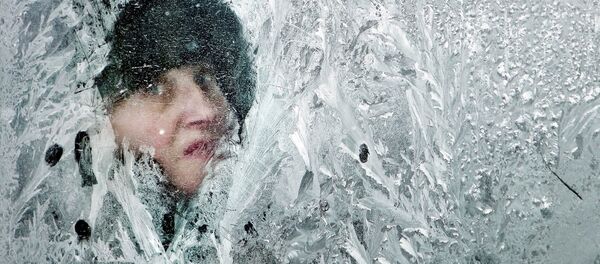 A woman looks out of a window covered in frost on a bus in Bucharest, Romania, in February 2012 - اسپوتنیک افغانستان  