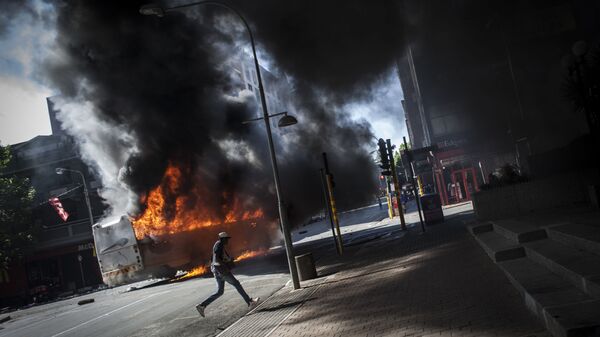 Автобус, подожженный во время столкновений студентов с полицией в Йоханнесбурге, ЮАР - اسپوتنیک افغانستان  