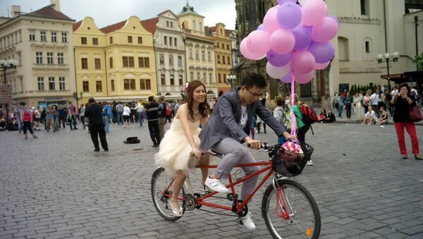 A newly married man from South Korea and his bride ride a bicycle at the Old Town Square in Prague - اسپوتنیک افغانستان  