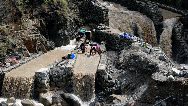 Local miners collect small rocks, as they mine for gold, from the waters that come from the mountains a day after Typhoon Haima struck Benguet province in northern Philippines, October 21, 2016 - اسپوتنیک افغانستان  