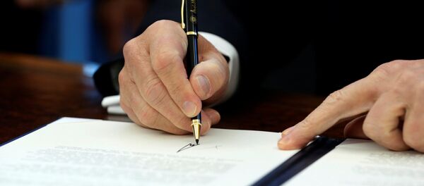 U.S. President Donald Trump signs a memorandum to security services directing them to defeat the Islamic State in the Oval Office at the White House in Washington, U.S. January 28, 2017 - اسپوتنیک افغانستان  