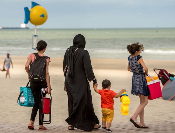 زن باحجاب همراه با اطفال در ساحل در شمال فرانسه - اسپوتنیک افغانستان  