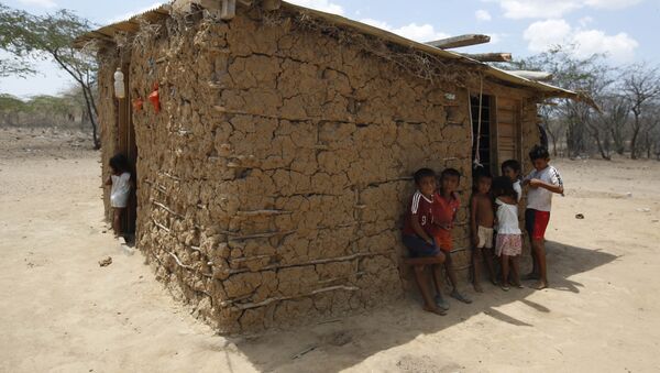 Wayuu indigenous children stand in the shade of their adobe home in Manaure, Colombia, Thursday, Sept. 10, 2015. Hunger exacerbated by a two-year-old drought is one of the biggest problems facing the Wayuu, a 600,000-strong ancestral tribe that’s caught in the middle of Venezuela’s crackdown on smuggling along its western border with Colombia - اسپوتنیک افغانستان  