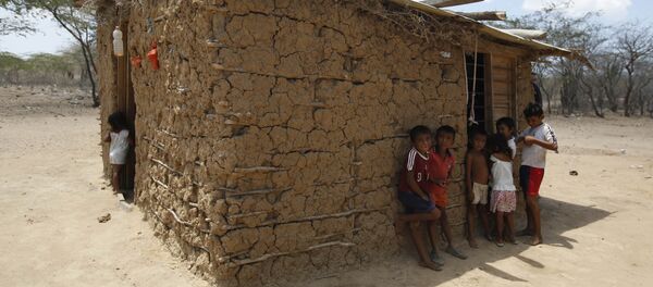 Wayuu indigenous children stand in the shade of their adobe home in Manaure, Colombia, Thursday, Sept. 10, 2015. Hunger exacerbated by a two-year-old drought is one of the biggest problems facing the Wayuu, a 600,000-strong ancestral tribe that’s caught in the middle of Venezuela’s crackdown on smuggling along its western border with Colombia - اسپوتنیک افغانستان  