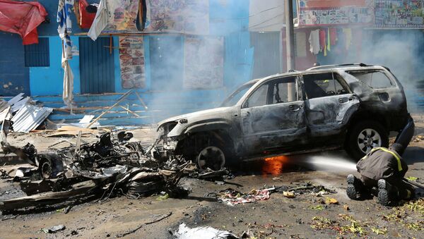 A firefighter tries to extinguish fire from the wreckage of a burning vehicle following an attack on a restaurant by the Somali Islamist group al Shabaab in the capital Mogadishu, Somalia, October 1, 2016 - اسپوتنیک افغانستان  