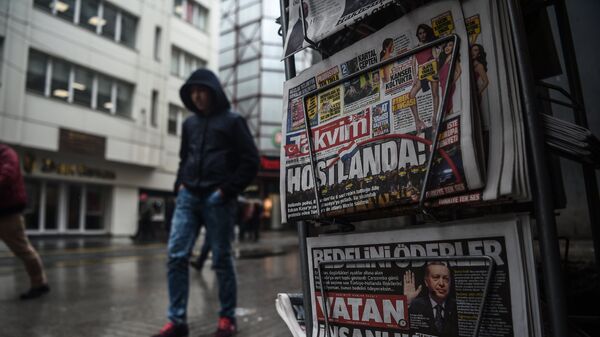 A person walks past a newspaper stand showing their front pages bearing headlines concerning diplomatic tensions between Turkey and The Netherlands, on display in Istanbul on March 13, 2017 - اسپوتنیک افغانستان  