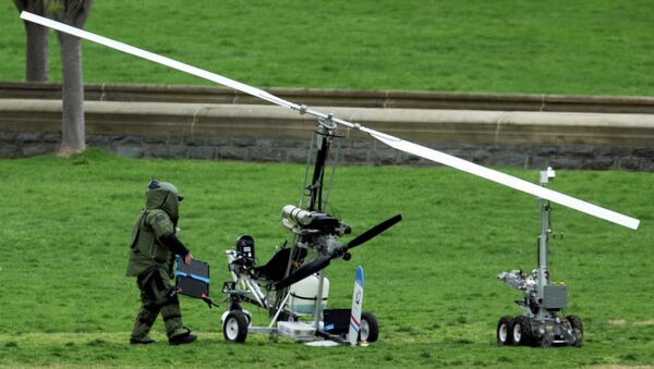 A member of a bomb squad checks a small helicopter after a man landed on the West Lawn of the Capitol in Washington, Wednesday, April 15, 2015. - اسپوتنیک افغانستان  