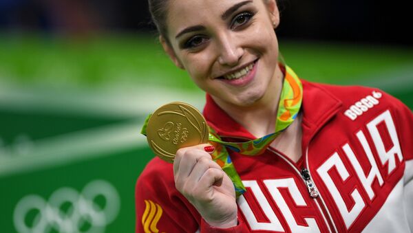 Aliya Mustafina (Russia), winner of the gold medal in the uneven bars event of the women’s artistic gymnastics competition at the XXXI Summer Olympics, during the medal ceremony - اسپوتنیک افغانستان  