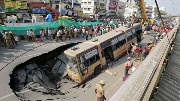 Спасатели готовятся к подъему пассажирского автобуса, провалившегося под асфальт в Ченнае, Индия - اسپوتنیک افغانستان  