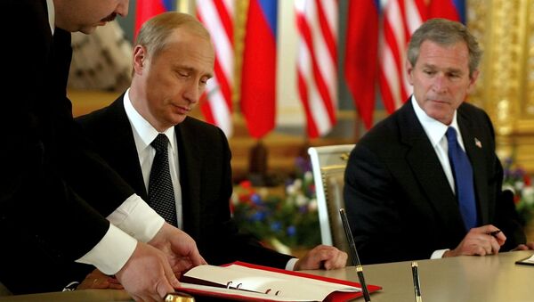 US President George W. Bush (R) looks on as Russian President Vladimir Putin (C) signs 24 May 2002 in St. Catherine's Room, the Kremlin in Moscow, Russia what the White House calls the Treaty of Moscow, a 10-year treaty binding the nations to reduce their nuclear stockpiles by about two-thirds - to a range of 1,700 to 2,200 - اسپوتنیک افغانستان  