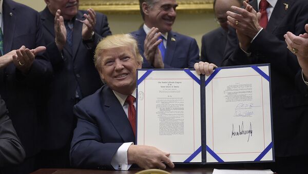 President Donald Trump hold up the Veterans Choice Program Extension and Improvement Act that he signed, Wednesday, April 19, 2017, in the Roosevelt Room of the White House in Washington - اسپوتنیک افغانستان  