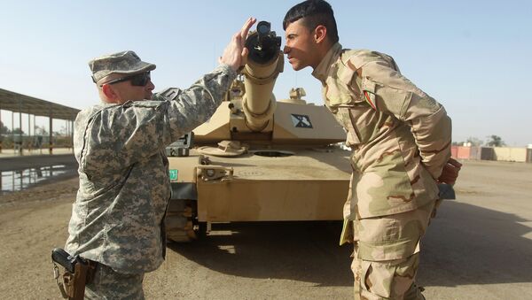 American military trainer shows an Iraqi soldier how to use a collimator to calibrate the gun barrel of an Abrams tank during a training session at the Taji base complex, which hosts Iraqi and US troops - اسپوتنیک افغانستان  